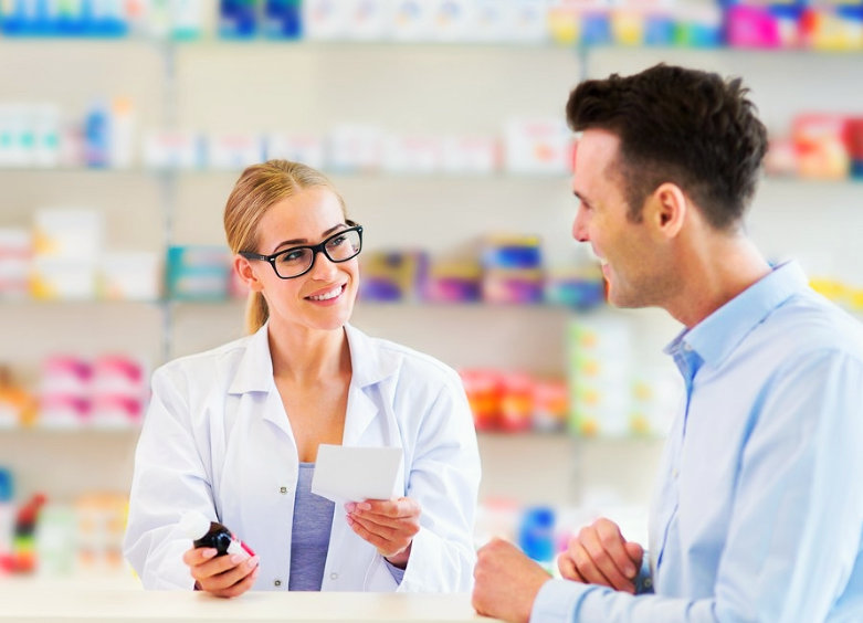 female pharmacist wearing eyeglasses talking with adult man smiling